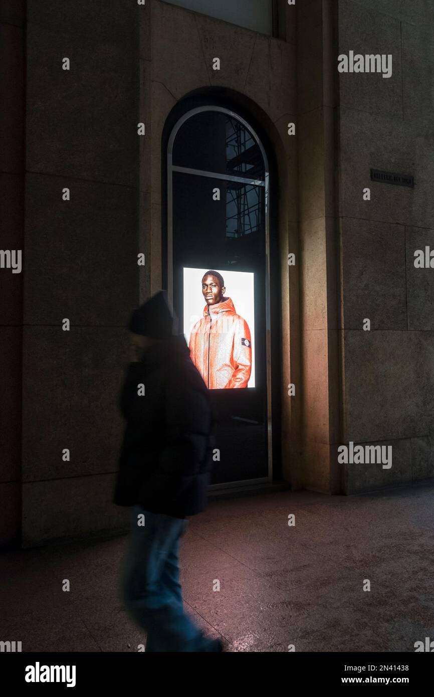 Stone Island window of flagship store in Milano, Italy. An image with coloured man wearing a jacket. How colored african models are used in fashion Stock Photo