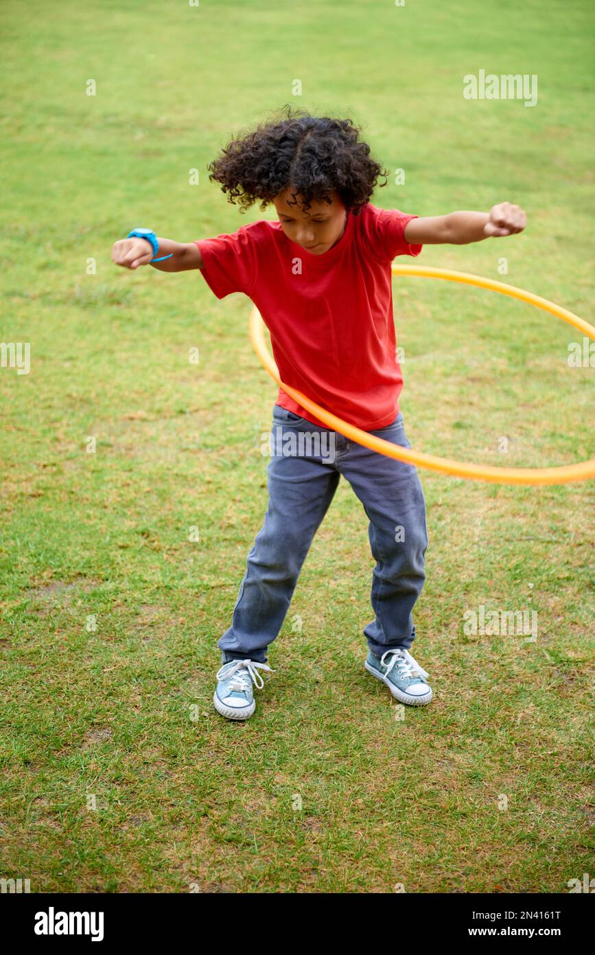 Keep it going. Full length shot of a young boy hula hooping outdoors Stock Photo Alamy