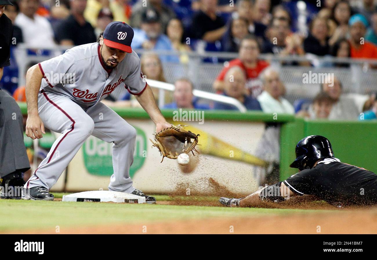 Miami Marlins Reed Johnson slides safely into third base on a throwing