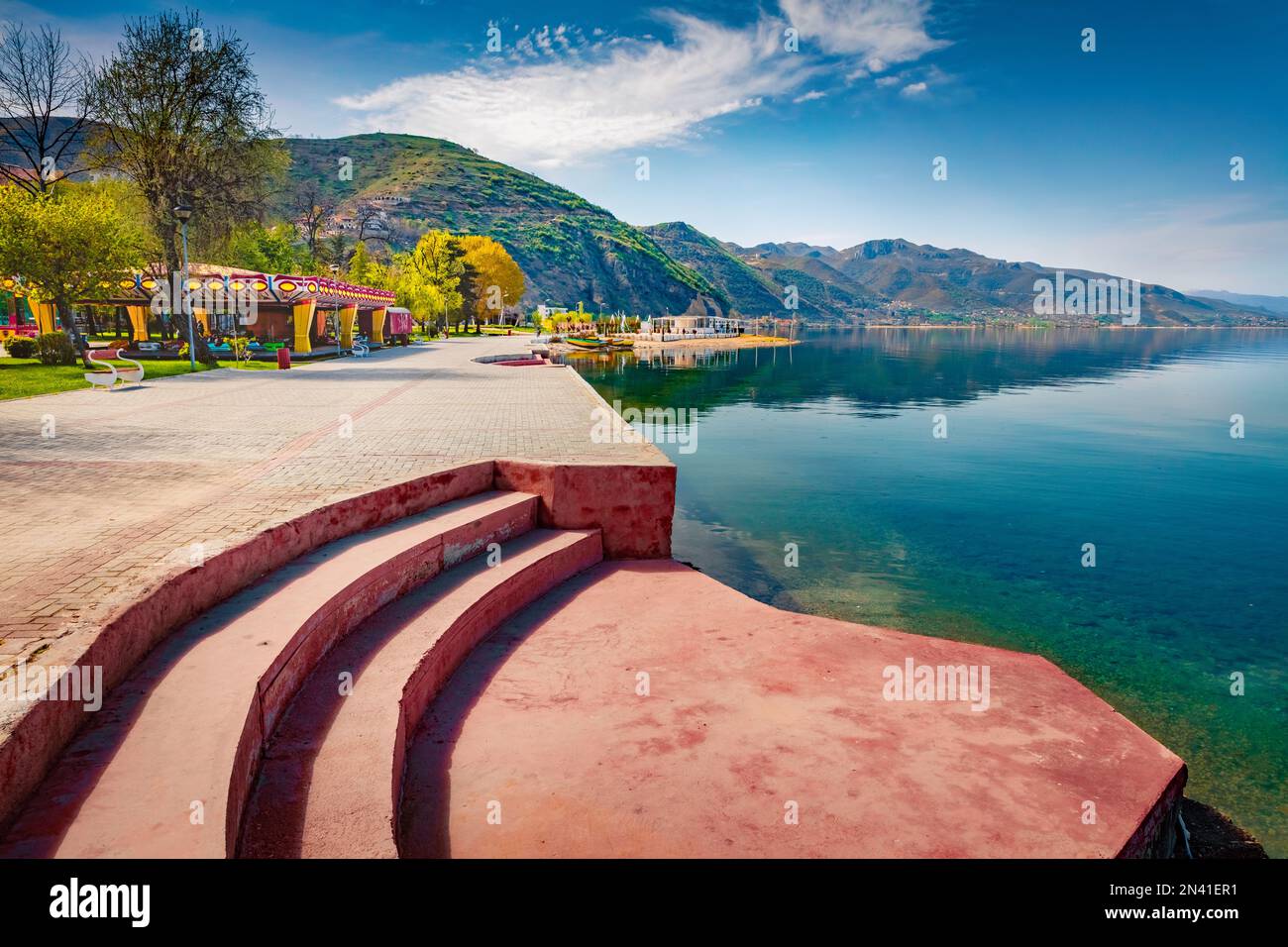 Sunny spring cityscape of Pogradec town. Stunning morning scene of Ohrid lake. Attractive landscape of Albania, Europe. Beauty of nature concept backg Stock Photo