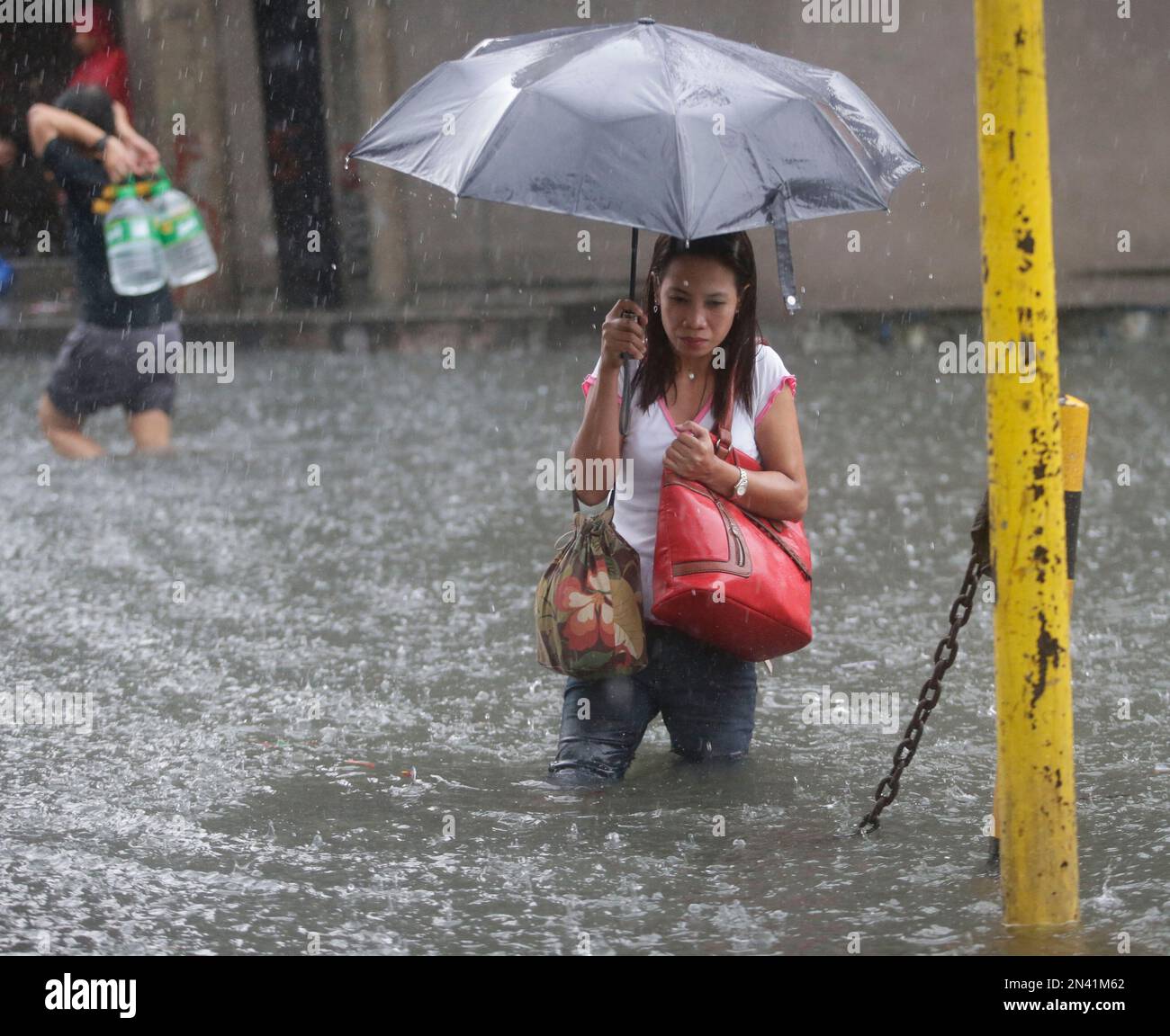Commuters wade through floodwaters after heavy monsoon rains spawned by ...