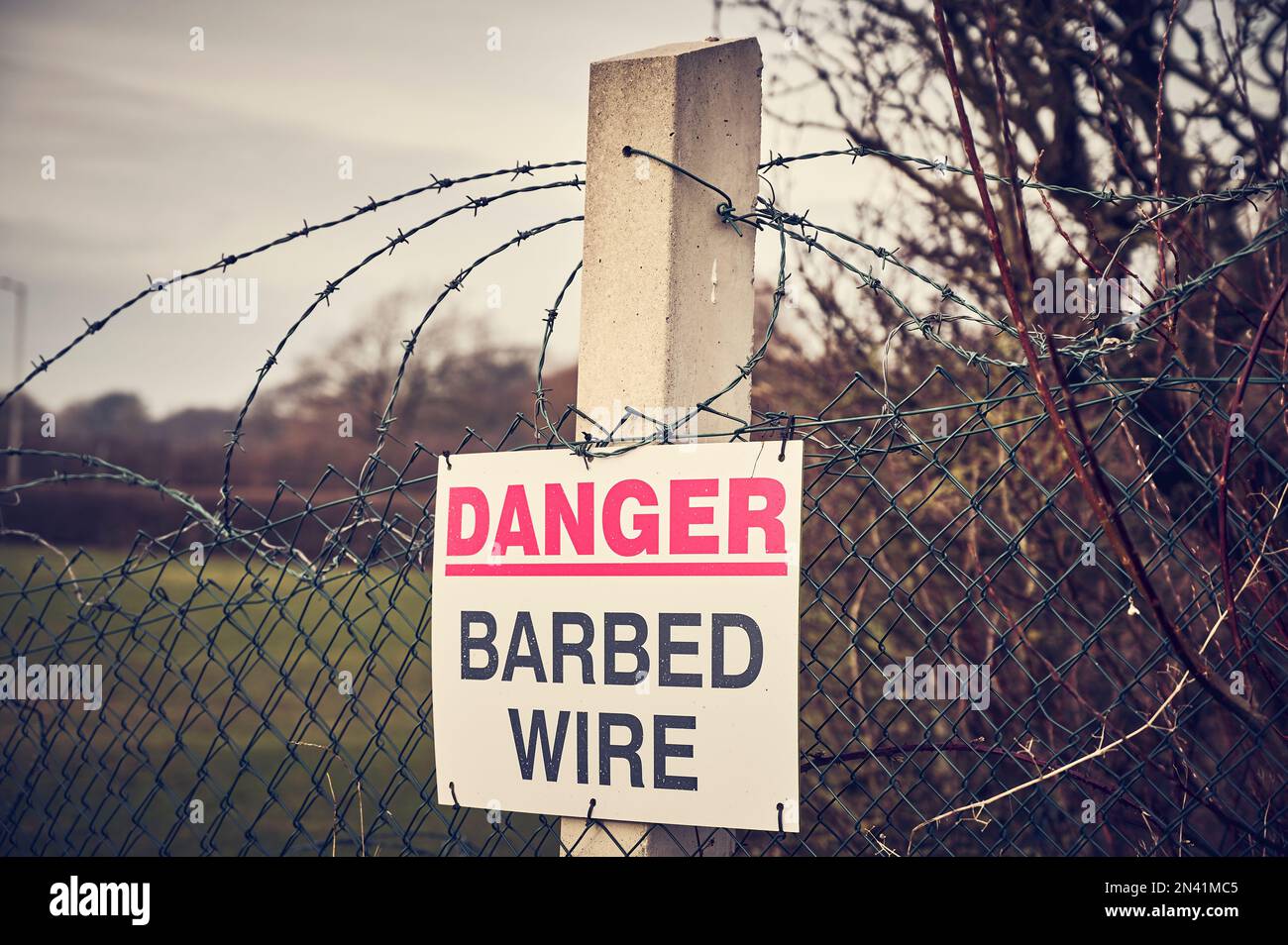 Sign Warning Of Barbed Wire Attached To Wire Fence Stock Photo Alamy