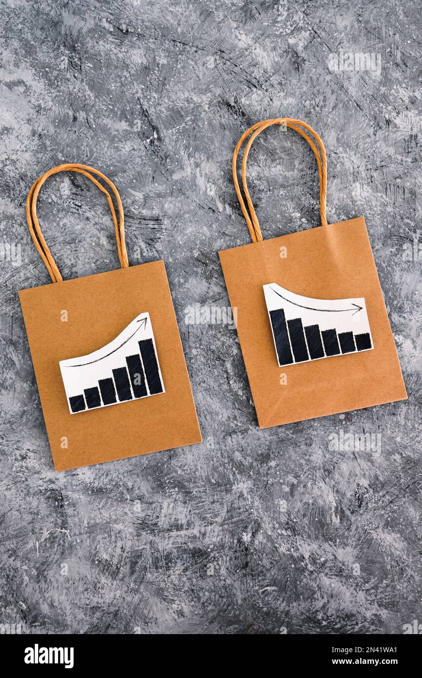 when will inflation go down. shopping bags with graph showing prices increasing then dropping, retail and groceries affecting cost of living conceptua Stock Photo