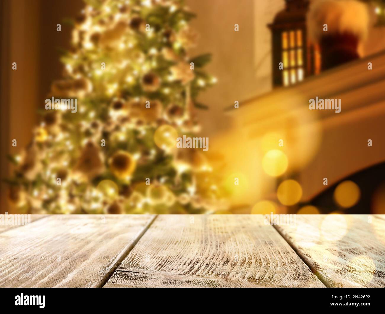 Empty wooden surface and blurred view of Christmas tree in room, space ...
