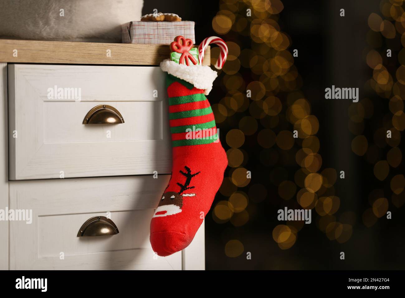 Stocking with presents hanging on drawer in children's room, space for ...