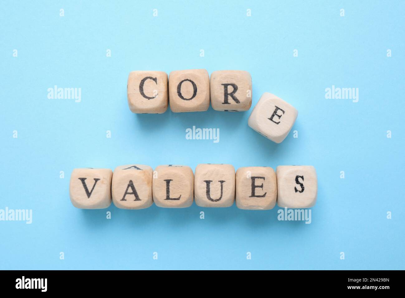 Beads with phrase CORE VALUES on light blue background, flat lay Stock Photo