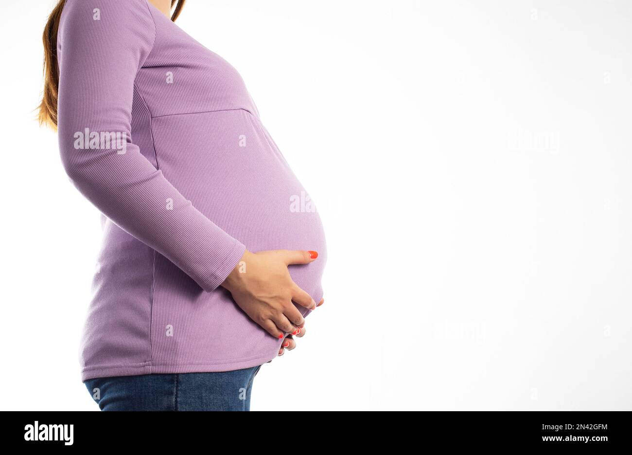 Pregnant girl in a purple sweater on a white background. The concept of