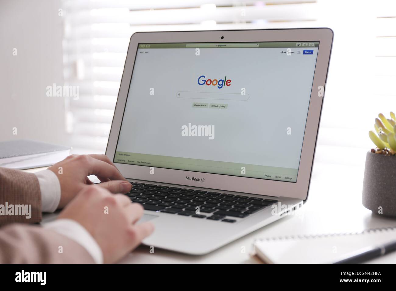 MYKOLAIV, UKRAINE - NOVEMBER 13, 2020: Woman using Google search on Apple Macbook Air in office, closeup Stock Photo