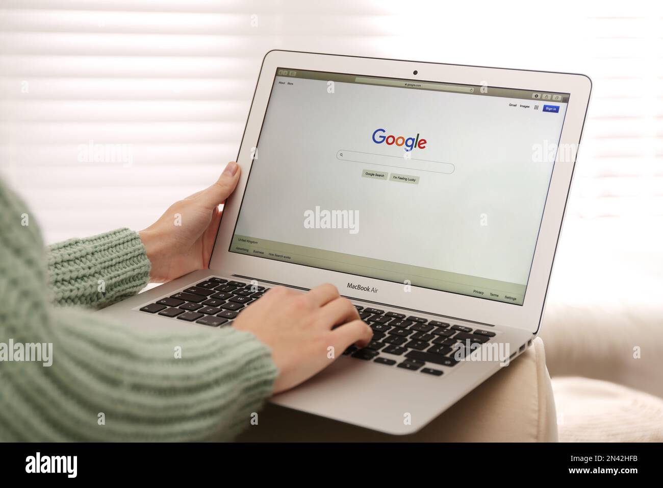 MYKOLAIV, UKRAINE - NOVEMBER 13, 2020: Woman using Google search on Apple Macbook Air in room, closeup Stock Photo