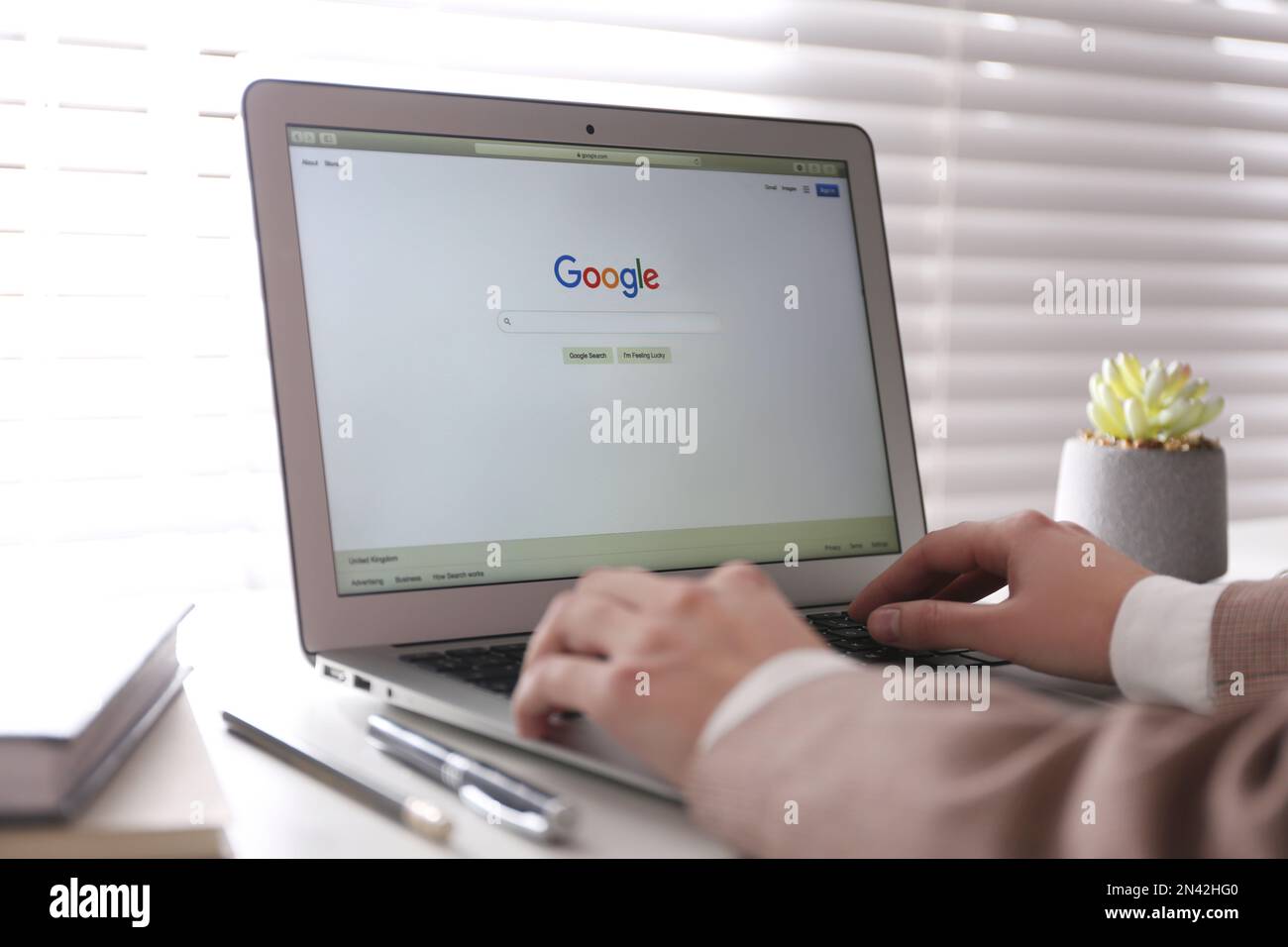 MYKOLAIV, UKRAINE - NOVEMBER 13, 2020: Woman using Google search on Apple Macbook Air in office, closeup Stock Photo