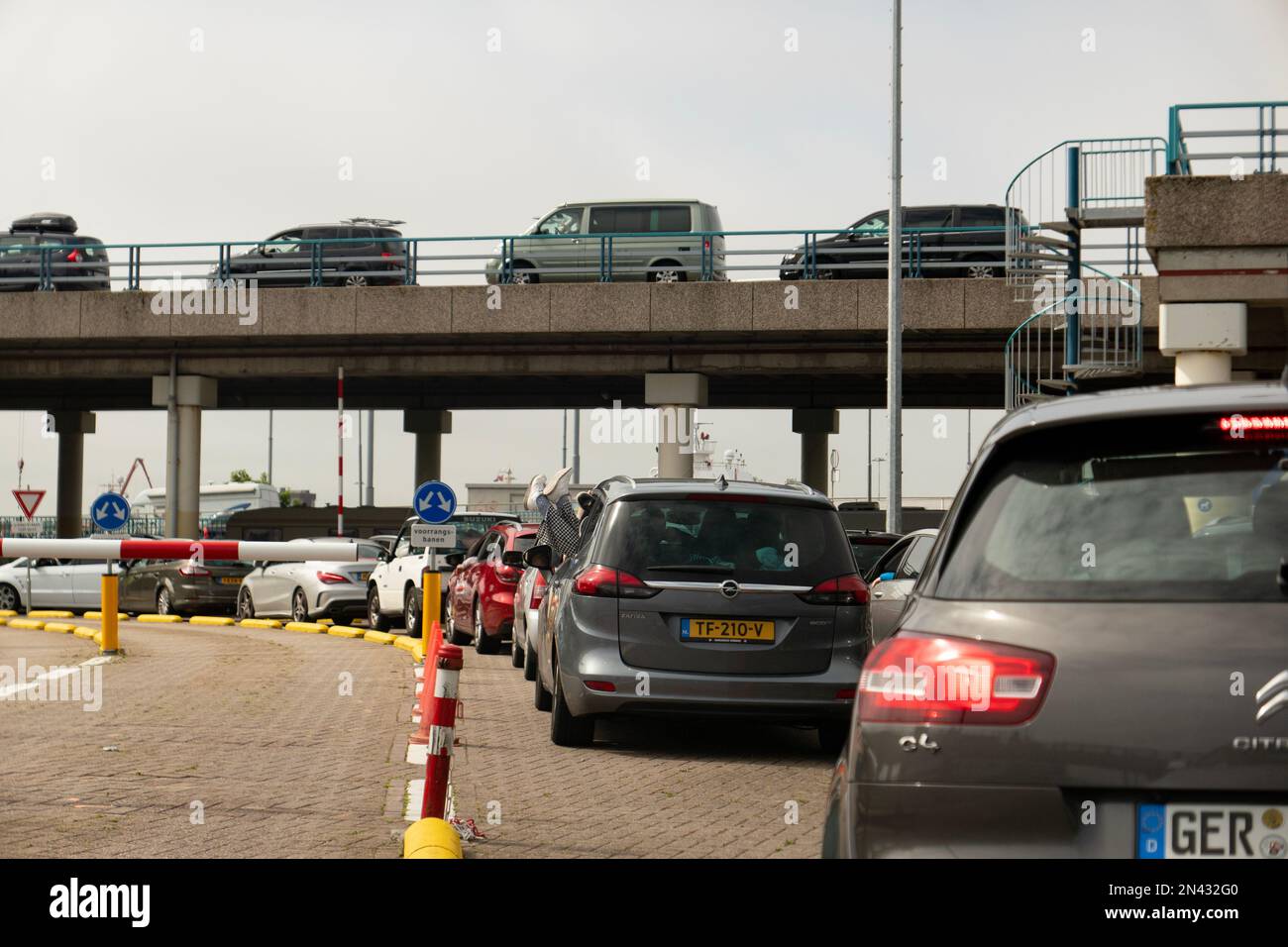 Cars waiting in a queue to get aboard ferry boat in the TESO Ferry Port in Den Helder, The Netherlands with destination Texel island Stock Photo