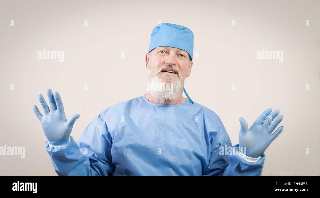Infectious disease doctor in blue protective shows hands in protective rubber gloves. Stock Photo