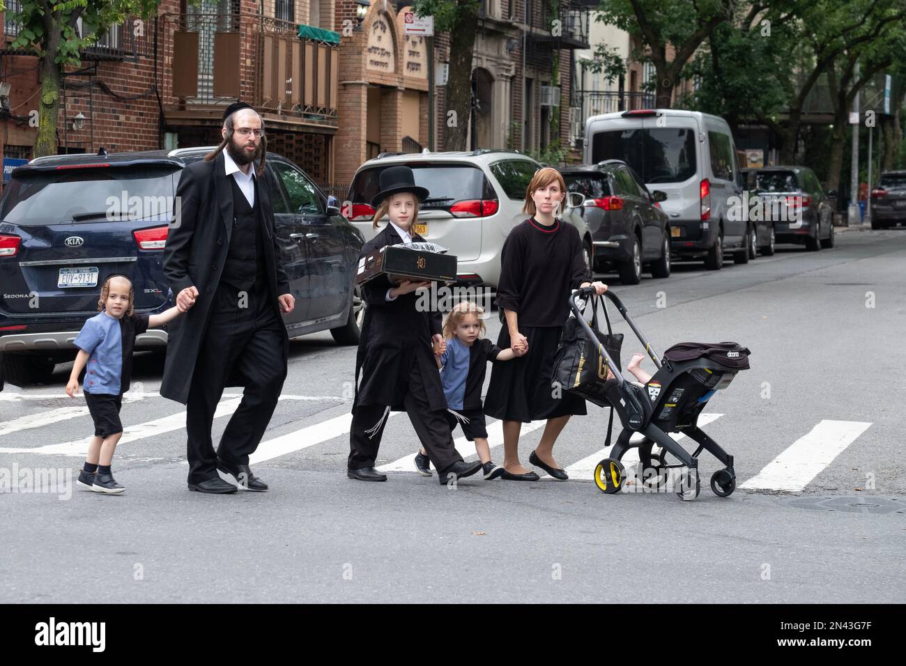 An orthodox jewish family crosses Bedford Avenue in Williamsburg, Brooklyn, New York City. A Jewish abbey Road. Stock Photo
