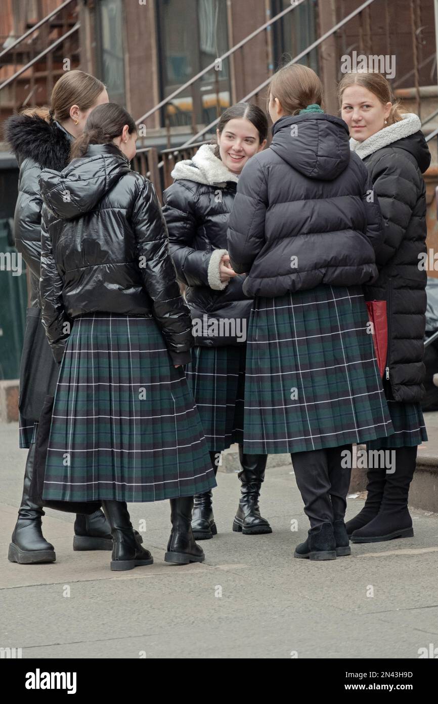 Hasidic Jewish girls wearing their school's uniform stop for a chat on their way home. They are wearing modest long plaid skirts. In Brooklyn, New Yor. Stock Photo