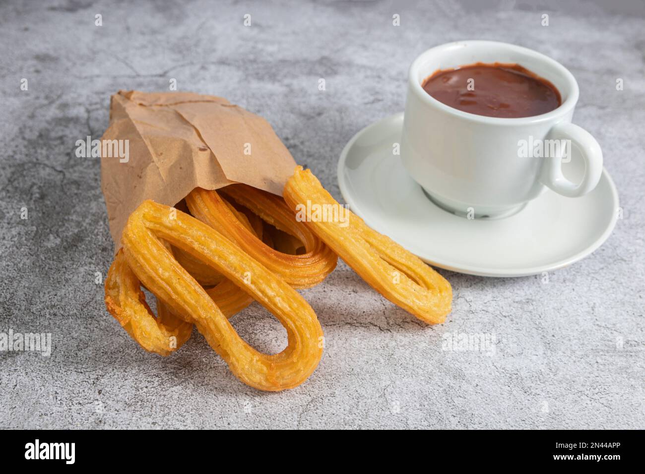 Churros in paper bag with cup of hot chocolate, typical spanish ...
