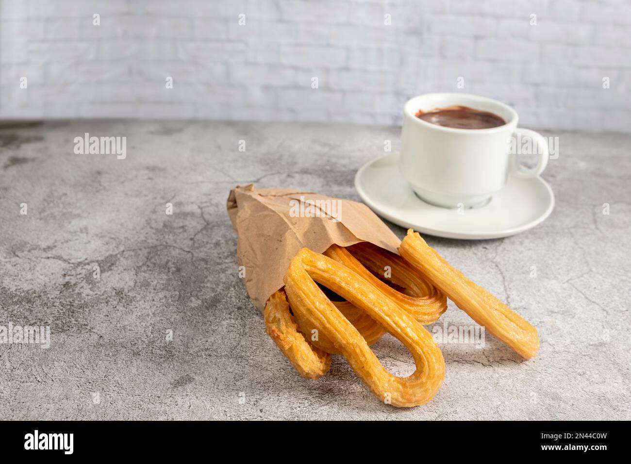 Churros in paper bag with cup of hot chocolate, typical spanish ...