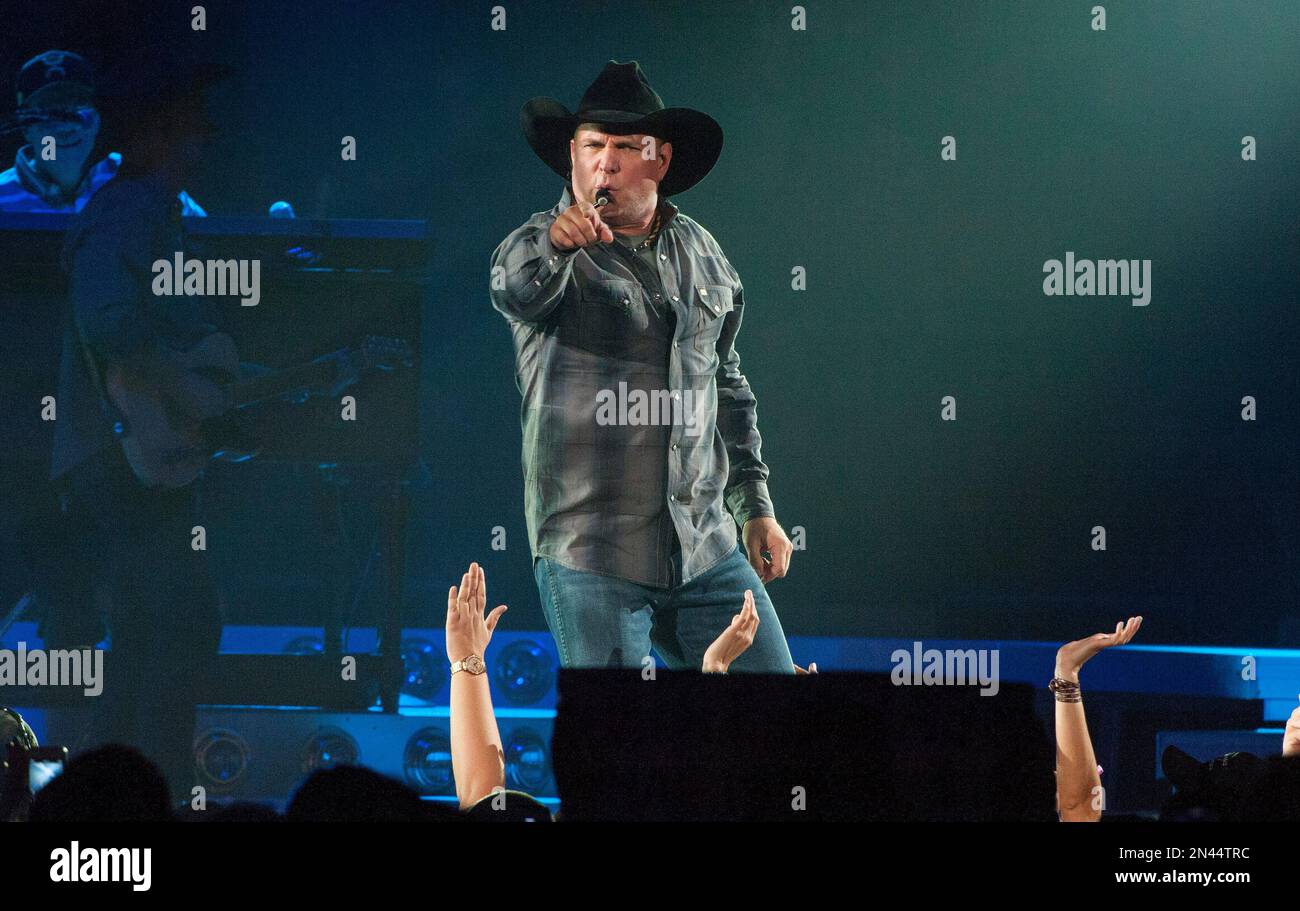 Country music star Garth Brooks, center wearing black cowboy hat, performs with band members