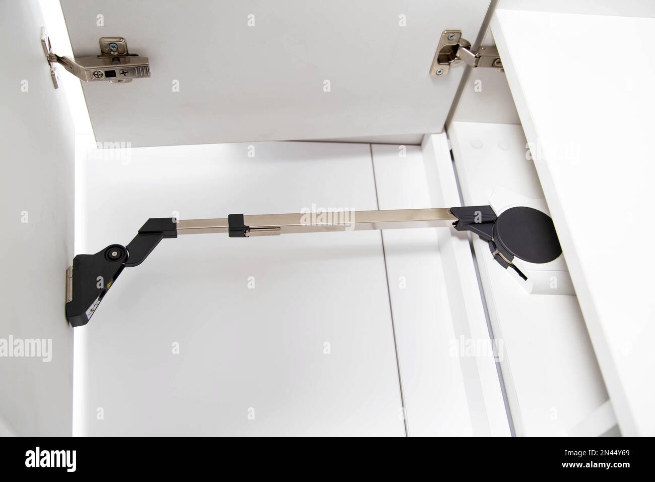 The modern lifting mechanism of a facade of a door with the closer.  Furniture kitchen fittings. Ergonomics Stock Photo - Alamy