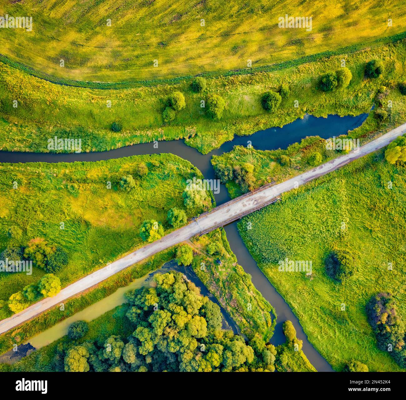 Straight dawn view from flying drone of bridge over small river, Ternopil region, Ukraine, Europe. Fresh green  scene of flooded valley. Beauty of nat Stock Photo