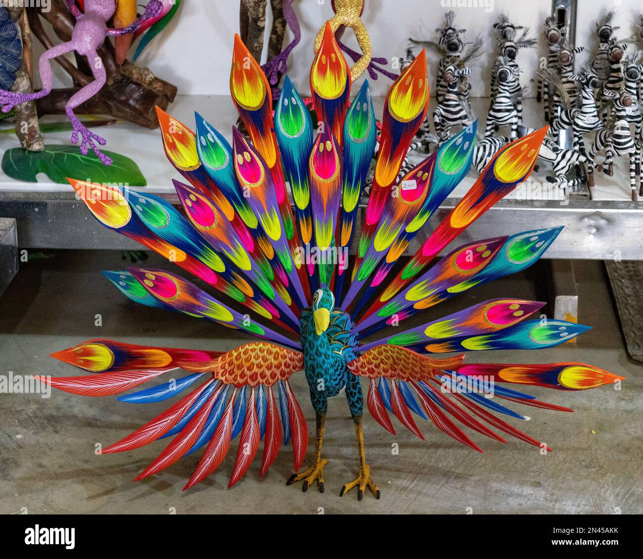 An alebrije peacock in an artisan's shop / workshop in San Antonio Arrazola, Oaxaca, Mexico.  Alebrijes are colorful painted creatures related to the Stock Photo