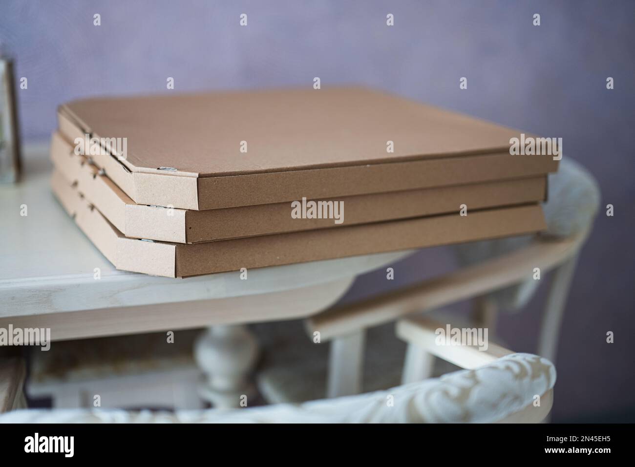 Cardboard pizza boxes on kitchen in table. Stock Photo