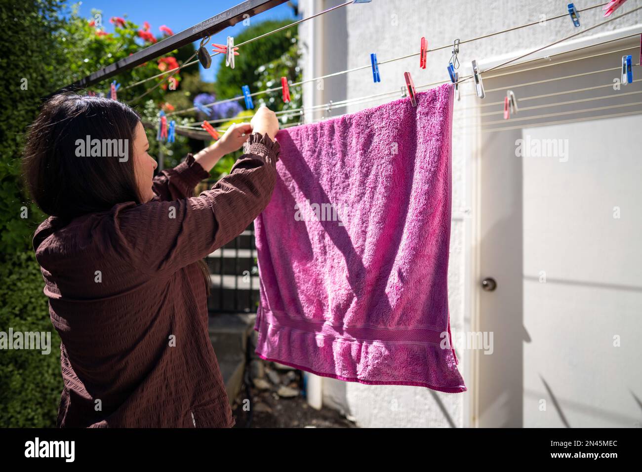 Drying clothes on a clothesline. drying a towel outside in Australia using pegs Stock Photo