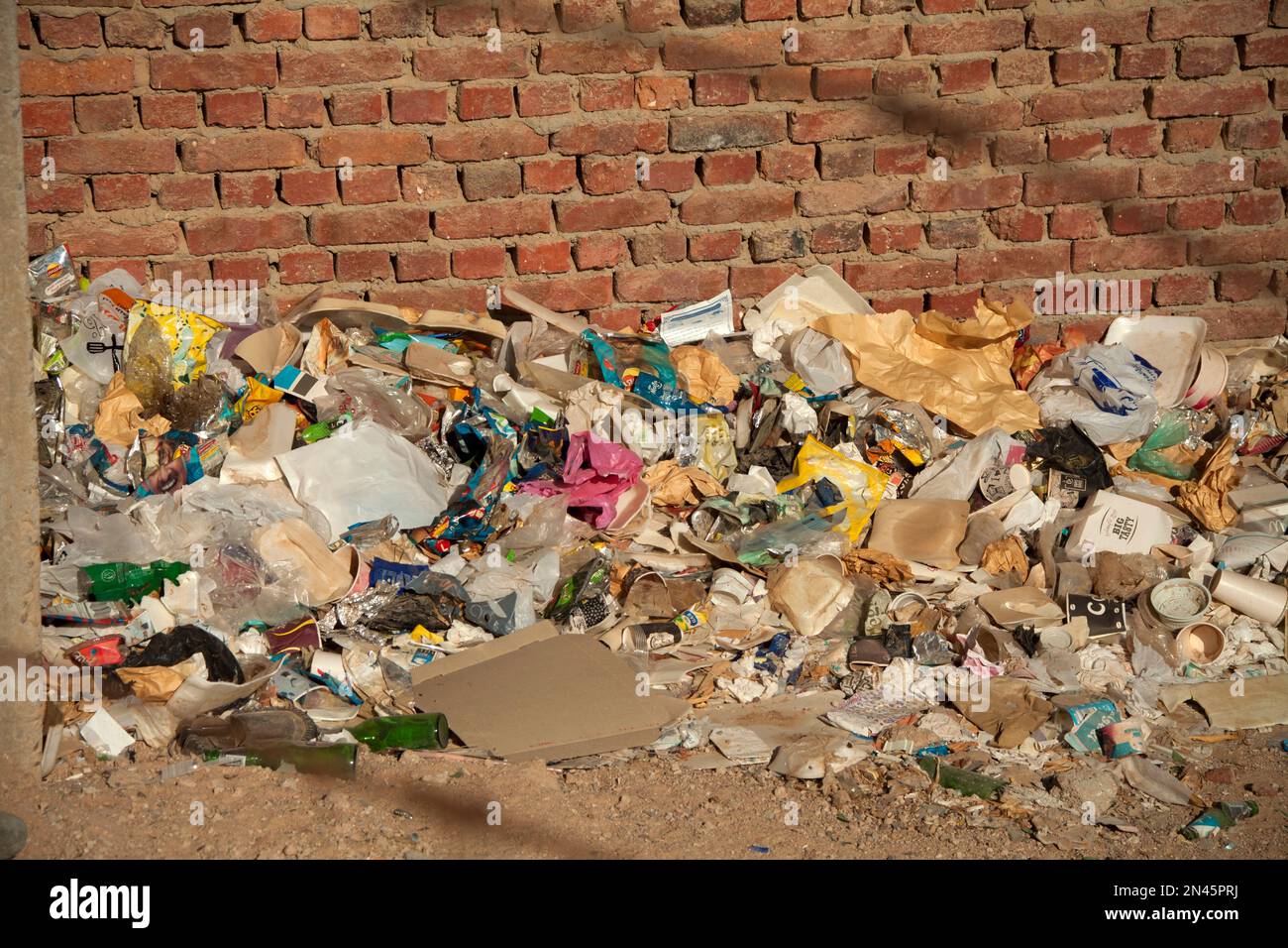 Trash and rubbish heap next to brick wall in Hurghada, Egypt Stock