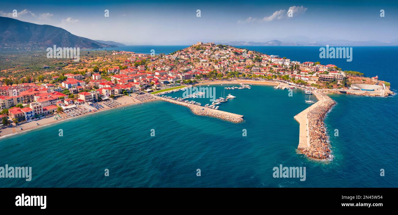 Panonoramic view from flying drone of Astros port. Sunny summer seascape of Myrtoan Sea. Aerial urban scene of Arcadia region, Greece, Europe. Traveli Stock Photo