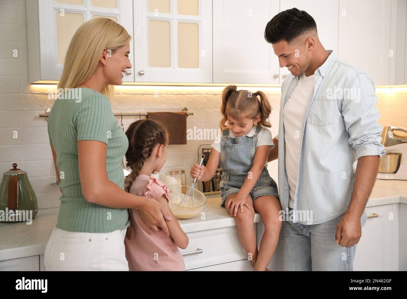Happy family cooking together in modern kitchen Stock Photo