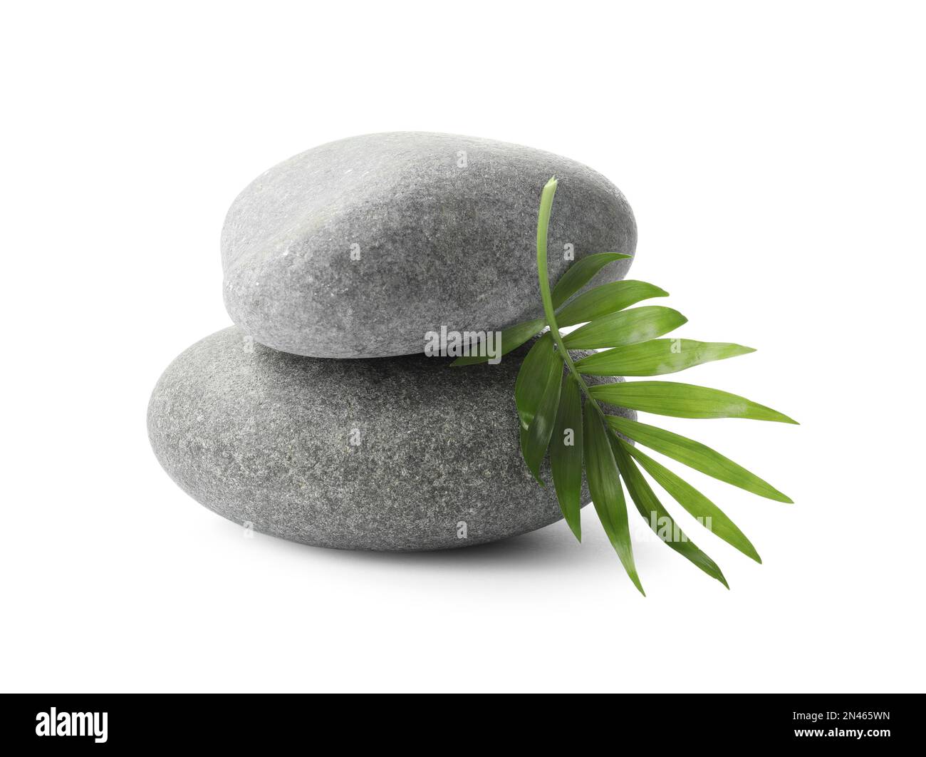 Grey spa stones and tropical leaf on white background Stock Photo