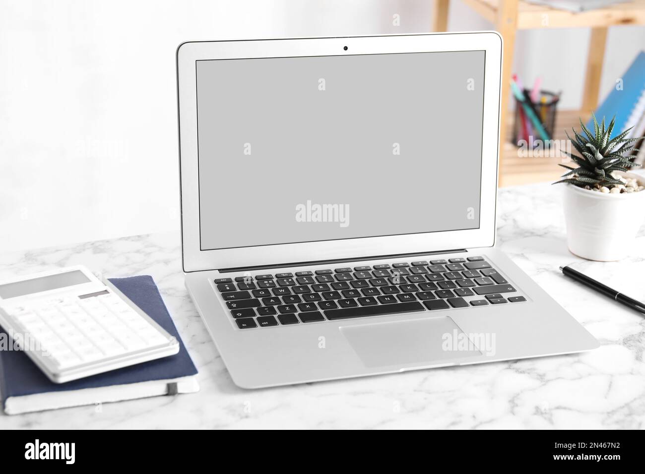 Modern laptop with blank screen on table in office Stock Photo - Alamy