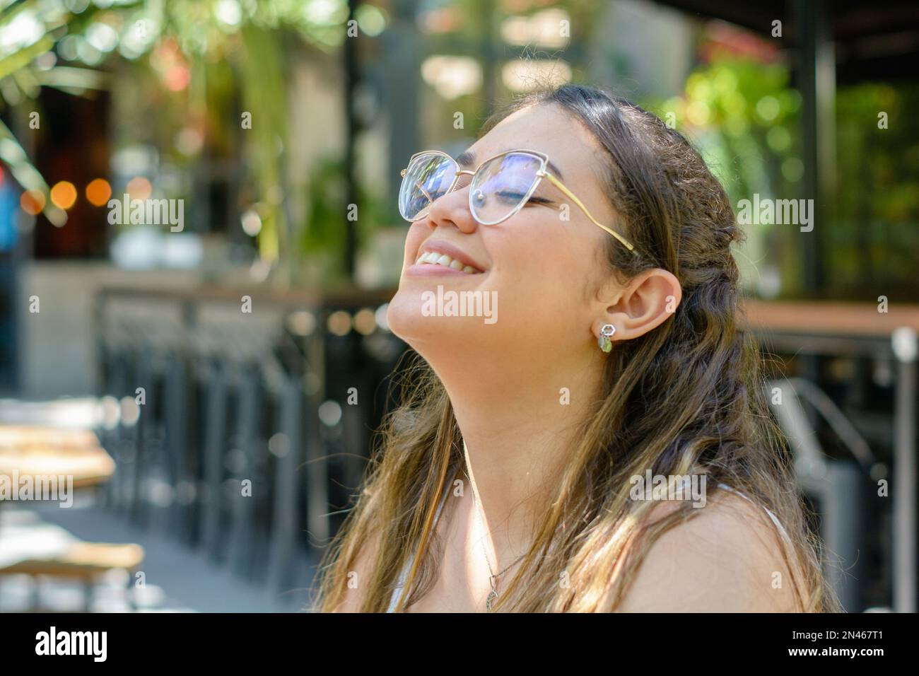 young latin venezuelan woman, with her eyes closed, laughing and
