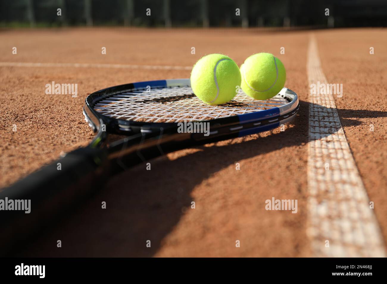 Tennis balls and racket on clay court, closeup Stock Photo - Alamy