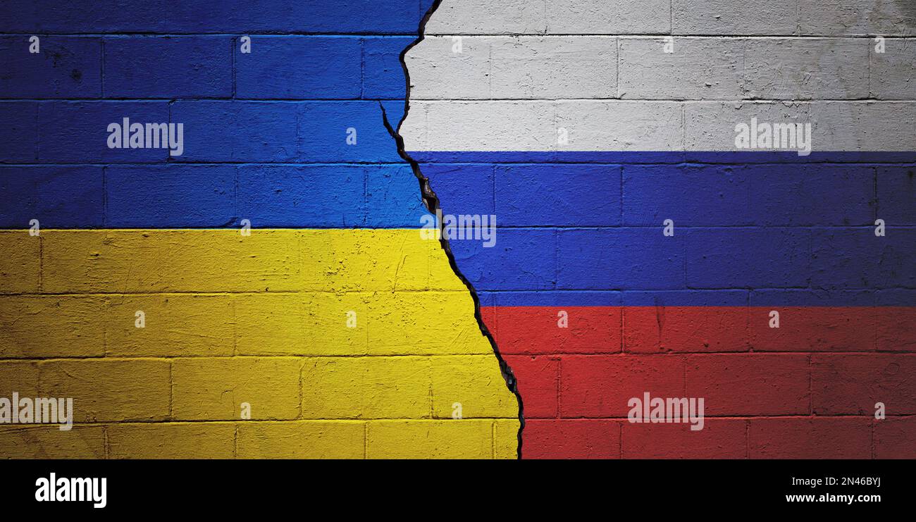 Cracked brick wall painted with a Ukrainian flag on the left and a Russian flag on the right. Stock Photo