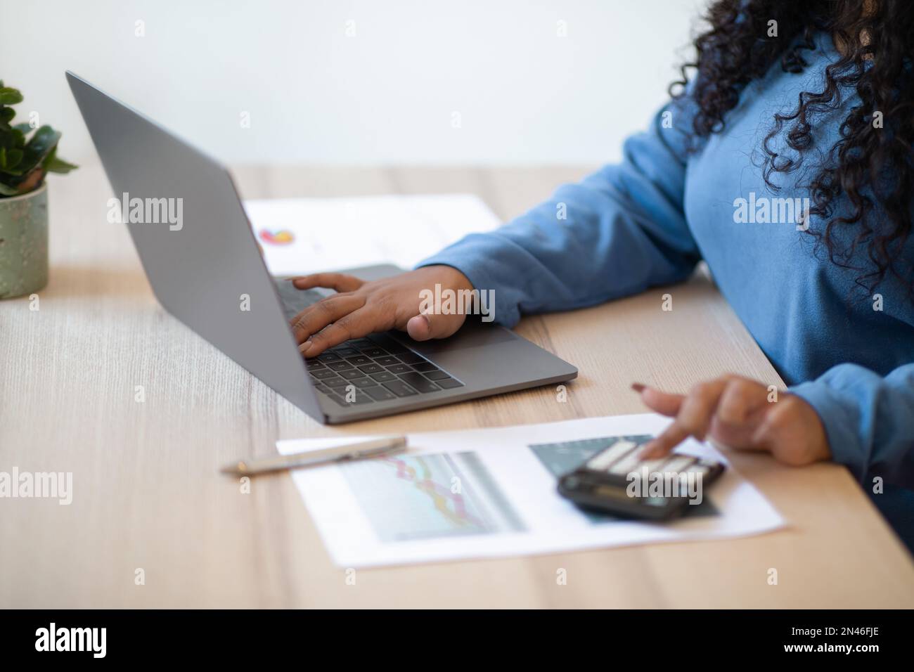Unrecognizable woman accountant using computer and calculator Stock Photo