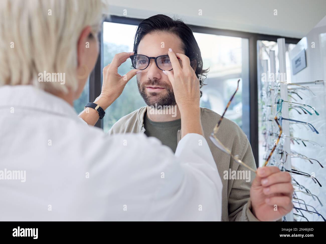 Optometrist, glasses and man in store for choice of frames, eyesight