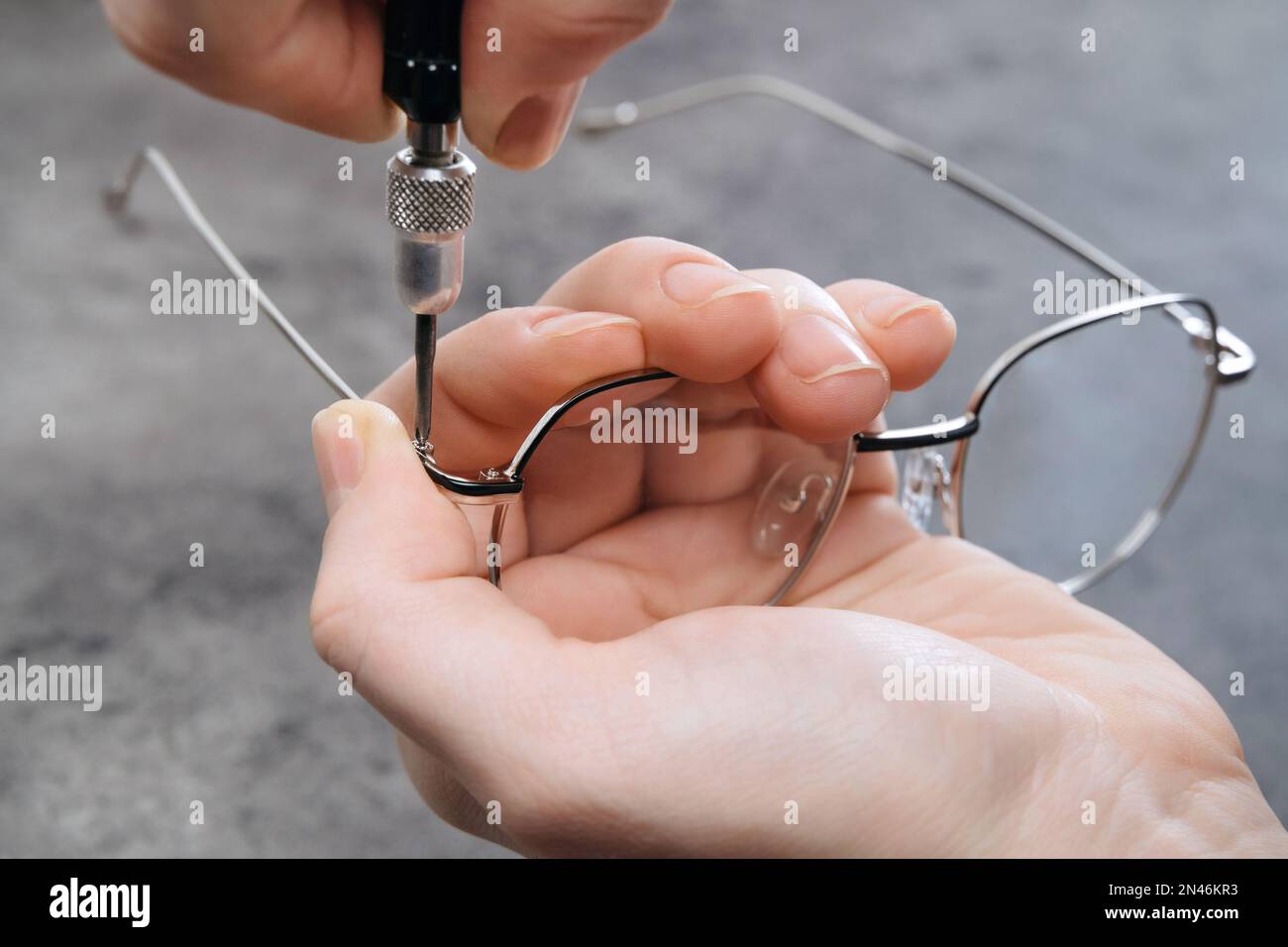 Closeup of optician master making new eyeglasses in optics using