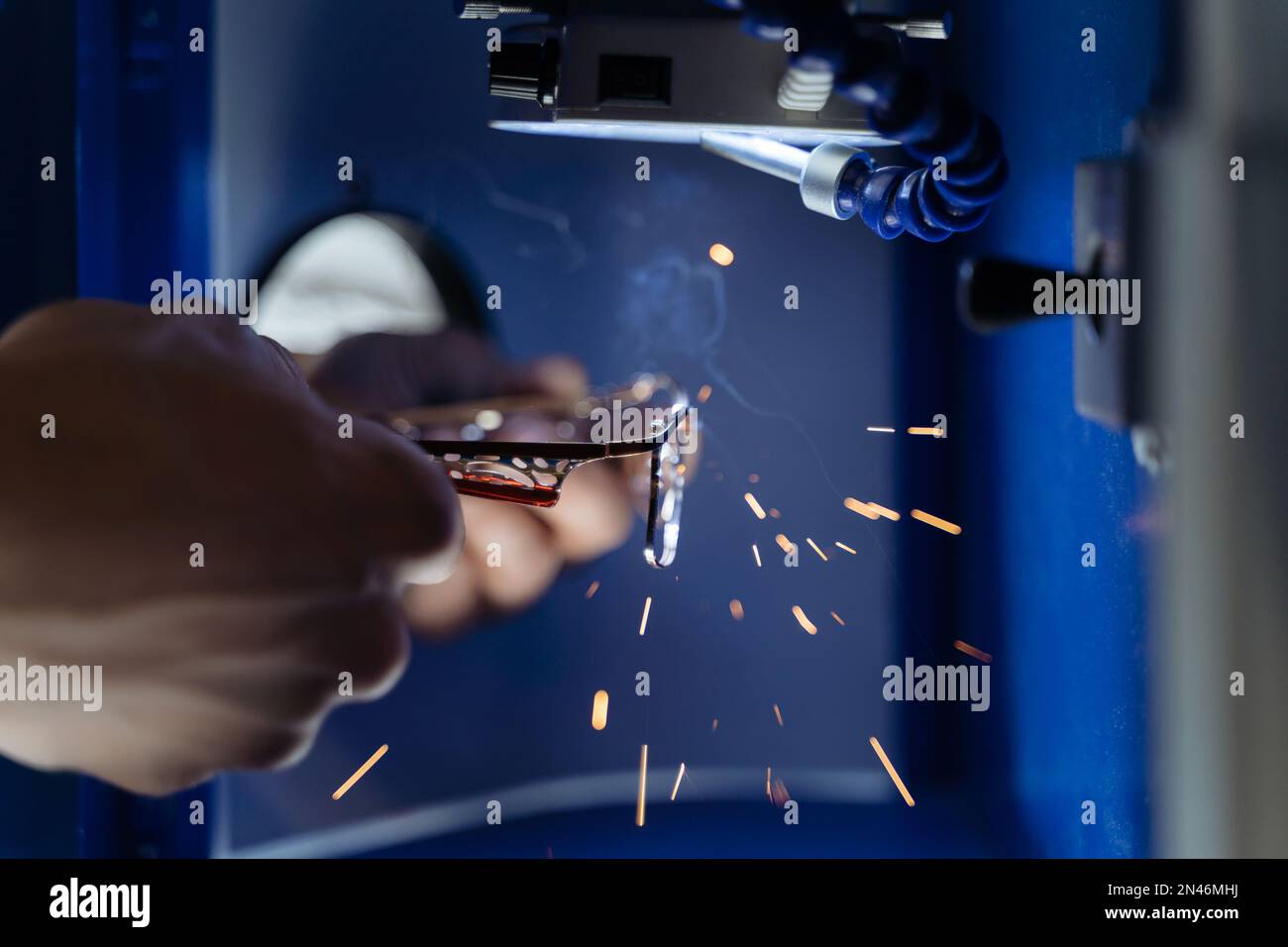 Closeup of man s hands repairing eyeglasses frame with laser welding machine in optical workshop. Glasses repair professional manufacturing laser soldering Stock Photo Alamy
