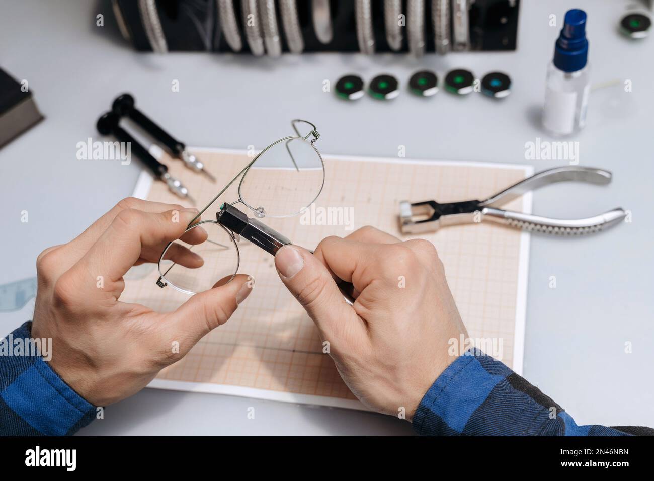 Young professional optical technician is fixing the bridge of