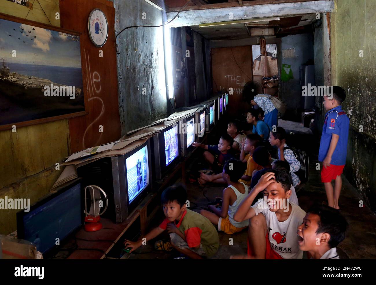 Indonesian young boys play video games at its rental house where people