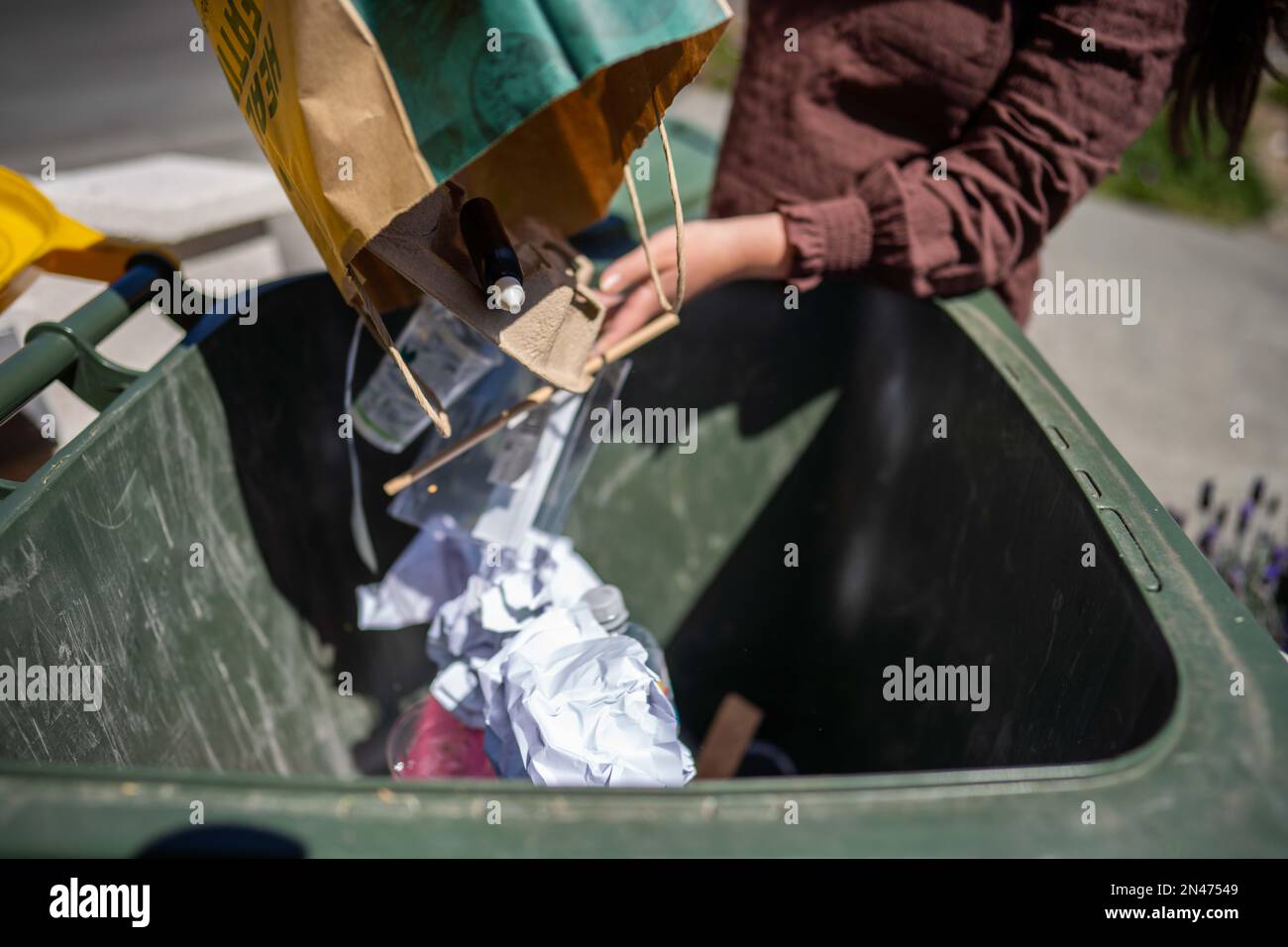 Throwing rubbish in the bin and sorting recycling. Putting rubbish in