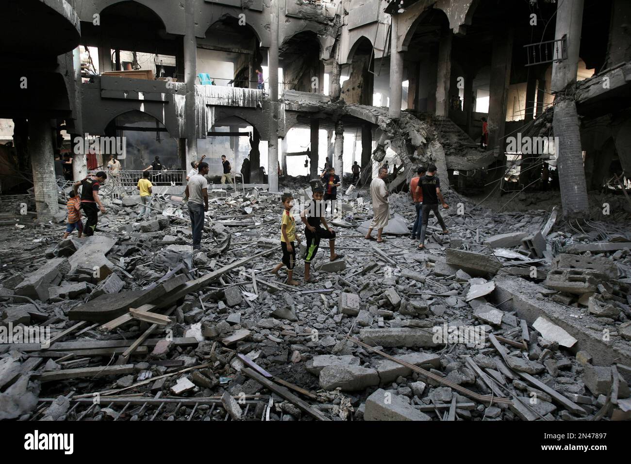 Palestinians inspect the damage of a Rafah commercial center after an ...