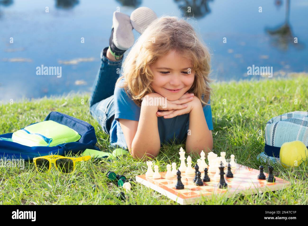 Pupil kid thinking about his next move in a game of chess. Concentrated  little boy sitting at the table and playing chess Stock Photo - Alamy