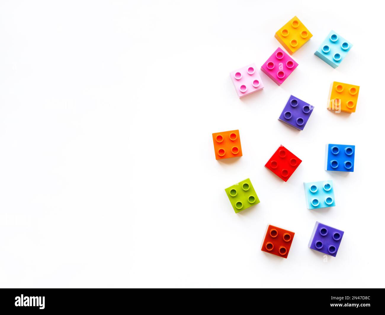 Colorful constructor blocks. Toy bricks without order. Place for text among multicolored toy details. Copy space. Stock Photo
