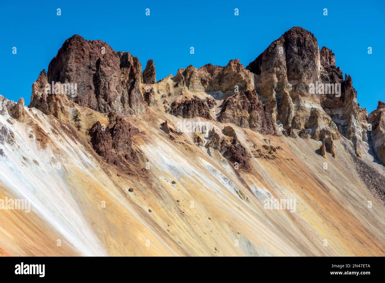 sharp black volcanic crater rocks with blue sky behind in Bolivia Stock ...