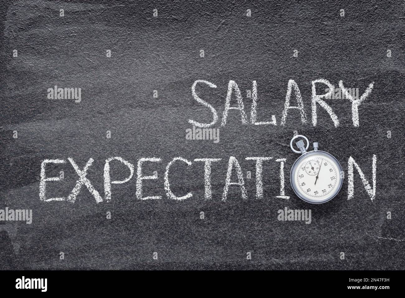 salary expectations phrase written on chalkboard with vintage precise stopwatch Stock Photo