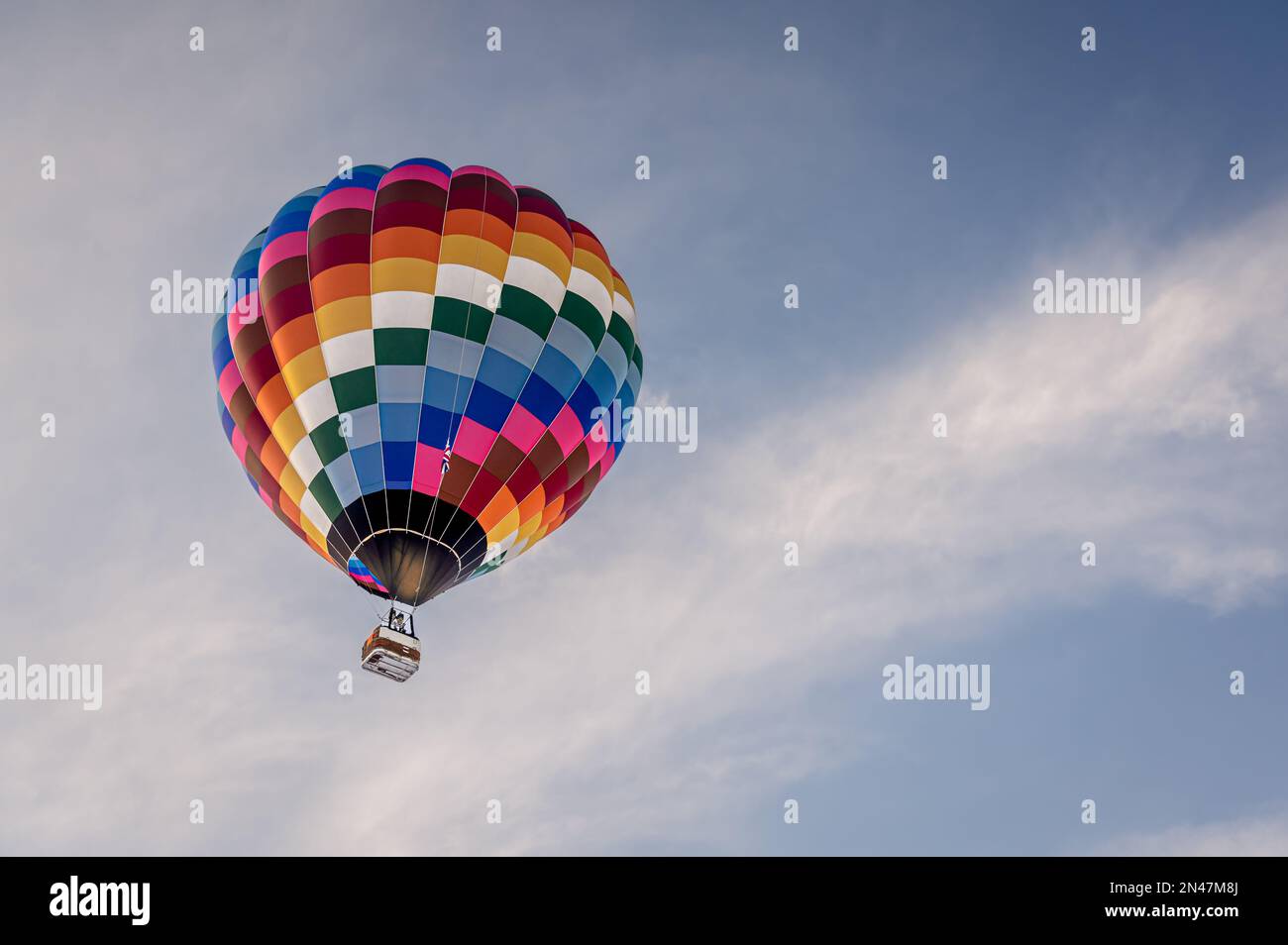 Hot Air Balloon in flight. One hot air ballooning flying in the sky in Switzerland. Chateau d'oex, Vaud, Switzerland. Stock Photo