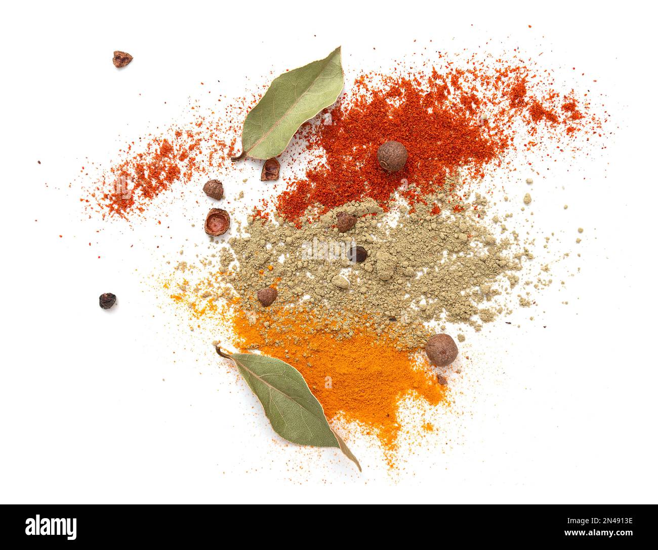 Dried turmeric or curcuma, paprika, pepper, bay leaf isolated on white