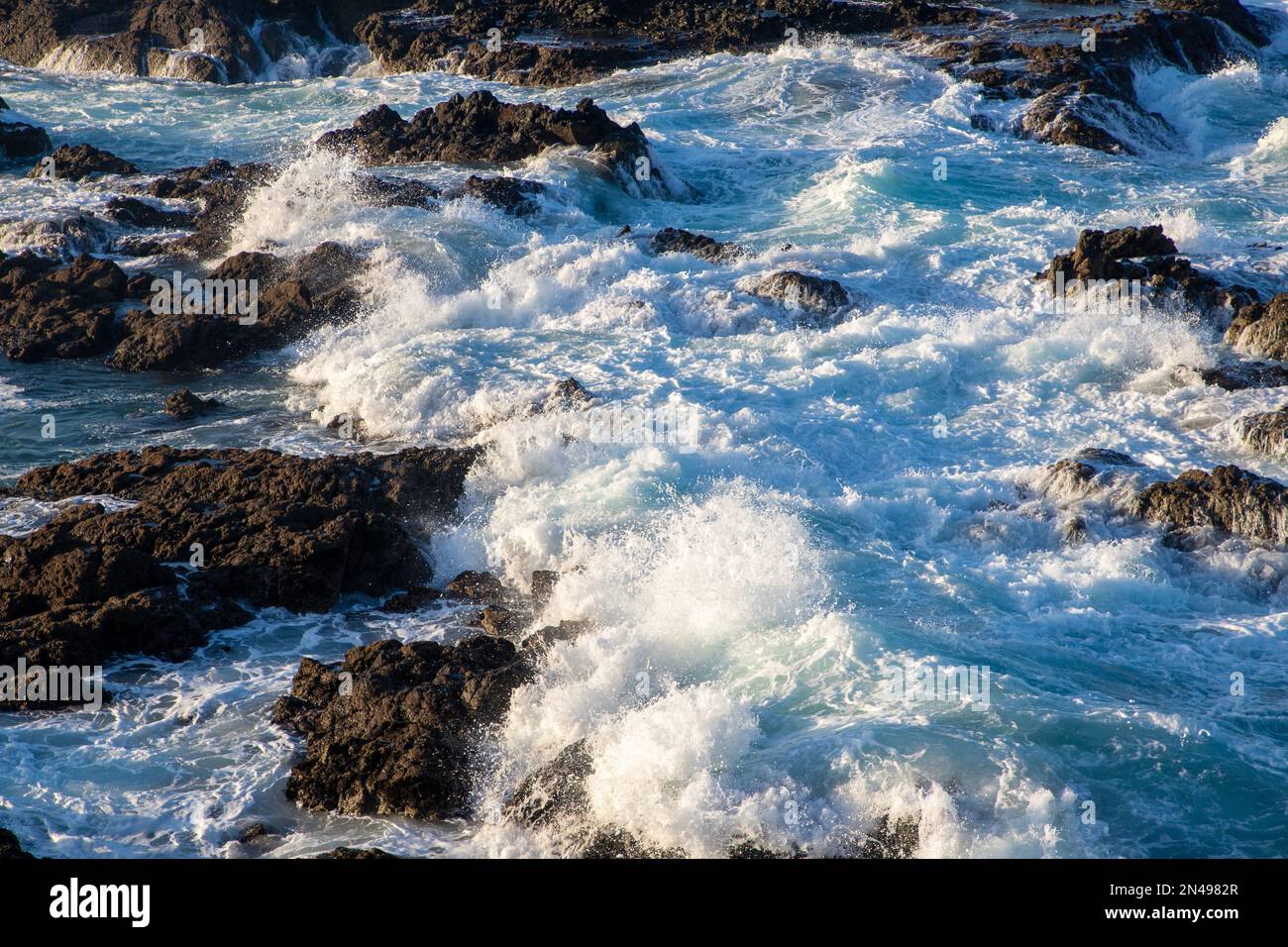 A close-up of a foamy water between rocks Stock Photo - Alamy