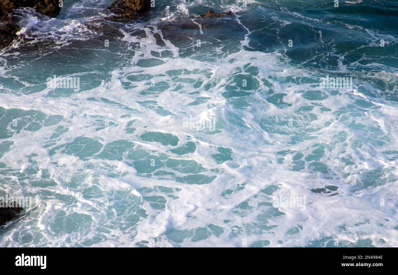 A close-up of a foamy water between rocks Stock Photo - Alamy